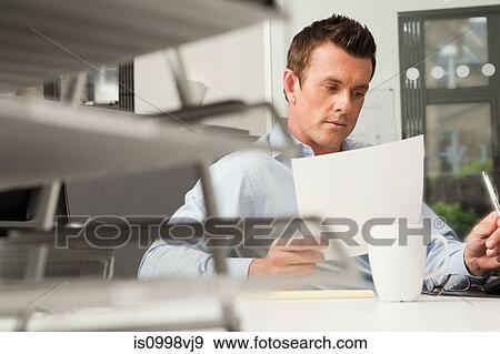 Office worker checking a document View Large Photo Image Stock Photo - Office worker checking a document. Fotosearch