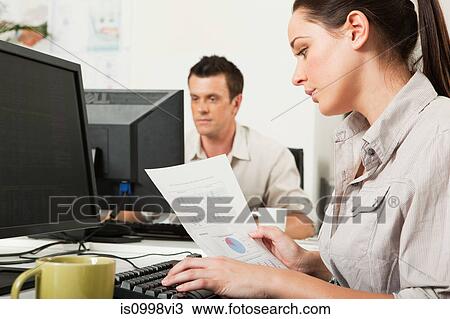 Office worker looking at graphs on a piece of paper View Large Photo Image Stock Image - Office worker looking at graphs on a piece of paper. Fotosearch