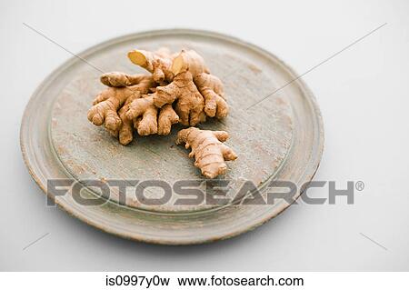 Stock Photo - Raw ginger on chopping board. Fotosearch