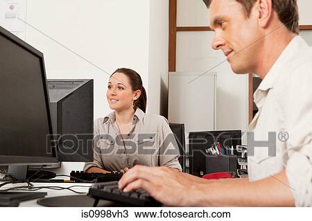 Two employees working on their computers in an office View Large Photo Image Stock Image - Two employees working on their computers in an office. Fotosearch