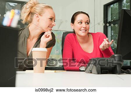 Two female employees looking at a computer View Large Photo Image Stock Image - Two female employees looking at a computer. Fotosearch