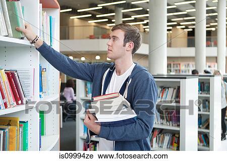 University student choosing textbooks in library View Large Photo Image Stock Image - University student choosing textbooks in library. Fotosearch