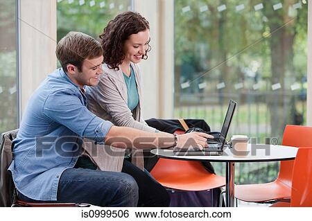 Stock Photograph - University student couple working on laptop. Fotosearch