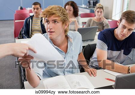 Stock Photo - University student receiving exam paper. Fotosearch