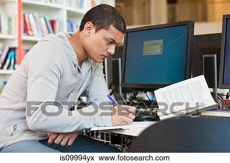 Stock Photo - University student working at computer desk. Fotosearch