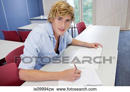 Stock Photo - University student writing on exam paper in class. Fotosearch