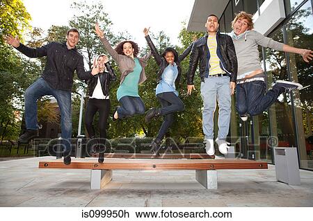 Stock Image - University students jumping at college. Fotosearch