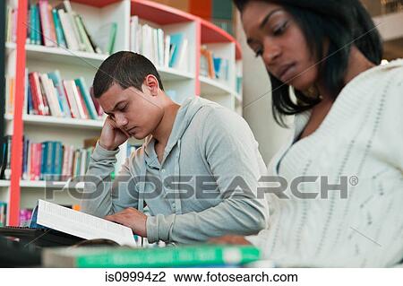 University students reading textbooks in college library View Large Photo Image Stock Image - University students reading textbooks in college library. Fotosearch