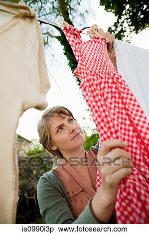 Woman hanging laundry on clothesline View Large Photo Image Stock Photography - Woman hanging laundry on clothesline. Fotosearch