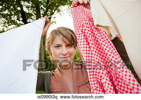 Woman hanging laundry on clothesline View Large Photo Image Stock Photography - Woman hanging laundry on clothesline. Fotosearch
