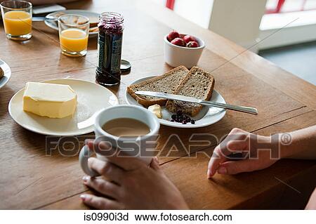Stock Image - Woman having breakfast, high angle. Fotosearch