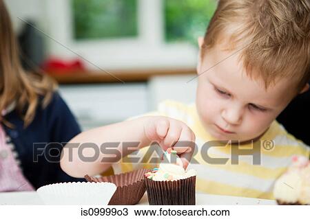Young boy decorating cupcakes View Large Photo Image Stock Image - Young boy decorating cupcakes. Fotosearch