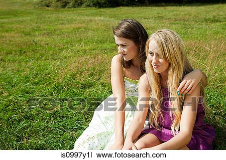 Young lesbian couple sitting side by side in a field View Large Photo Image Stock Image - Young lesbian couple sitting side by side in a field. Fotosearch