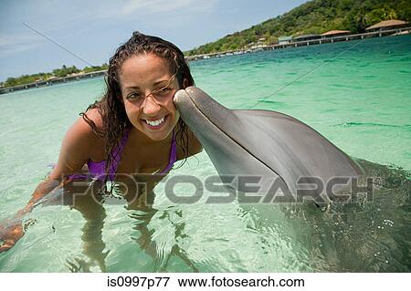 Young woman smiling with dolphin in sea View Large Photo Image Stock Photo - Young woman smiling with dolphin in sea. Fotosearch