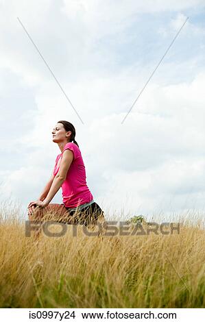 Young woman stretching off in a field View Large Photo Image Picture - Young woman stretching off in a field. Fotosearch