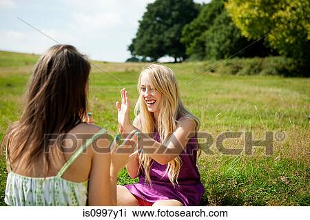 Young women playing patacake in a field View Large Photo Image Stock Image - Young women playing patacake in a field. Fotosearch