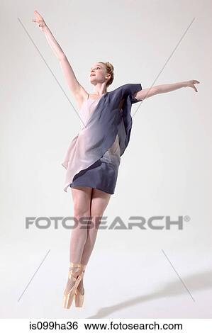 Stock Photograph - Ballerina jumping with arms raised and toes pointed. Fotosearch