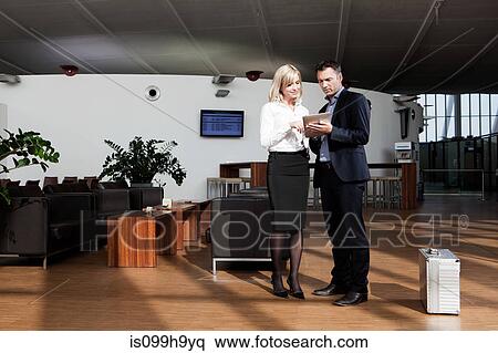 Business partners looking at data tablet in airport View Large Photo Image Stock Photography - Business partners looking at data tablet in airport. Fotosearch