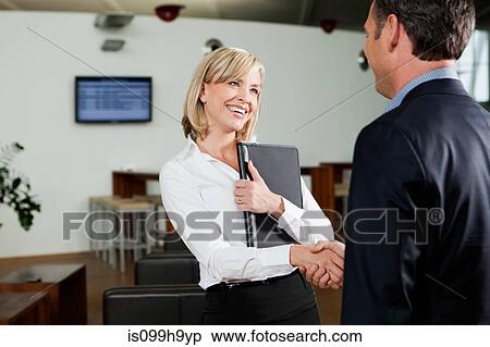 Business partners shaking hands in airport View Large Photo Image Stock Photography - Business partners shaking hands in airport. Fotosearch