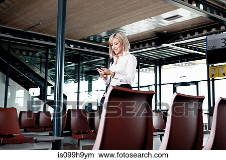 Businesswoman using phone in airport View Large Photo Image Picture - Businesswoman using phone in airport. Fotosearch