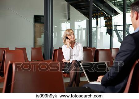 Businesswoman using phone in departure lounge of airport View Large Photo Image Stock Image - Businesswoman using phone in departure lounge of airport. Fotosearch