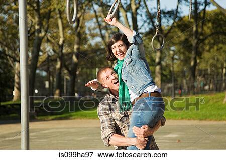 Couple playing in children's playground View Large Photo Image Stock Photo - Couple playing in children's playground. Fotosearch