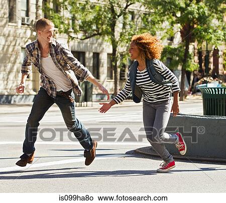 Couple running through city street View Large Photo Image Picture - Couple running through city street. Fotosearch