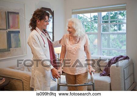 Doctor supporting senior woman on walking frame View Large Photo Image Stock Photography - Doctor supporting senior woman on walking frame. Fotosearch
