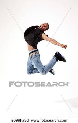 Stock Image - Jubilant young man in mid air. Fotosearch