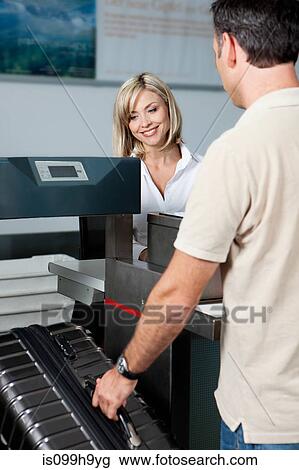 Man at check in desk of airport View Large Photo Image Stock Image - Man at check in desk of airport. Fotosearch