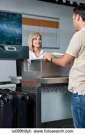 Man at check in desk of airport View Large Photo Image Stock Image - Man at check in desk of airport. Fotosearch