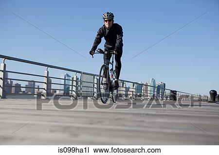 Man cycling over bridge View Large Photo Image Stock Image - Man cycling over bridge. Fotosearch