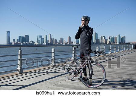 Stock Image - Man doing up bike helmet strap. Fotosearch