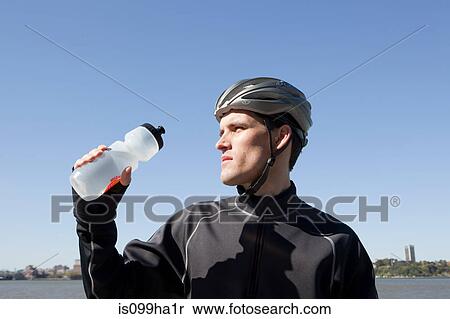 Man in cycling gear quenching thirst View Large Photo Image Stock Photography - Man in cycling gear quenching thirst. Fotosearch