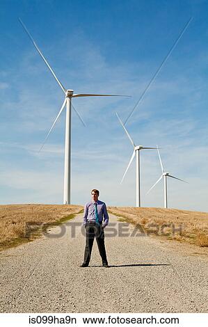 Man in front of wind turbines View Large Photo Image Picture - Man in front of wind turbines. Fotosearch