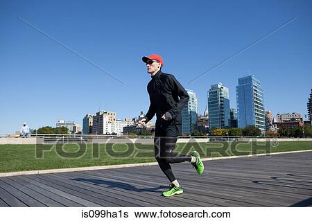 Stock Photograph - Man jogging on timber walkway. Fotosearch