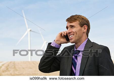 Man on mobile phone in front of wind turbines View Large Photo Image Stock Image - Man on mobile phone in front of wind turbines. Fotosearch