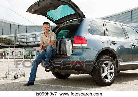 Man sitting on cart in airport carpark View Large Photo Image Stock Photo - Man sitting on cart in airport carpark. Fotosearch