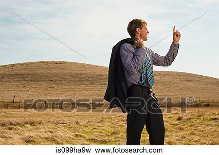 Man surveying landscape with finger in the air View Large Photo Image Stock Photo - Man surveying landscape with finger in the air. Fotosearch
