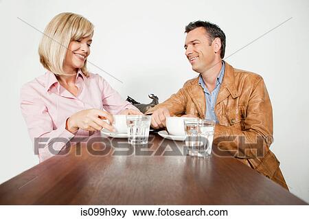 Mid adult couple sitting in cafe of airport View Large Photo Image Stock Photo - Mid adult couple sitting in cafe of airport. Fotosearch