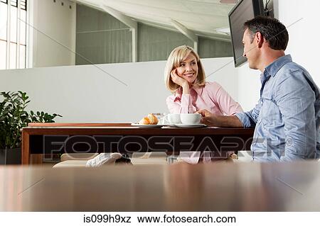 Mid adult couple sitting in cafe of airport View Large Photo Image Stock Photo - Mid adult couple sitting in cafe of airport. Fotosearch