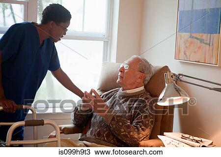 Nurse looking after senior man at home View Large Photo Image Stock Image - Nurse looking after senior man at home. Fotosearch