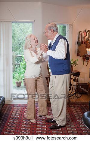 Senior couple dancing together in living room View Large Photo Image Stock Image - Senior couple dancing together in living room. Fotosearch