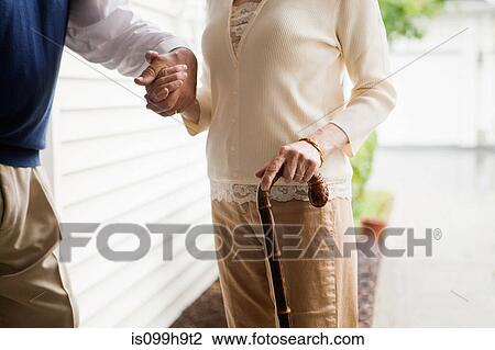 Senior couple standing with walking stick View Large Photo Image Stock Image - Senior couple standing with walking stick. Fotosearch