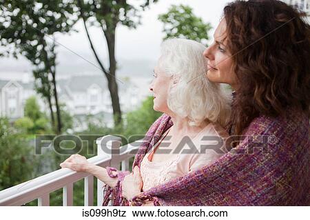 Senior woman and daughter embracing on porch View Large Photo Image Stock Photo - Senior woman and daughter embracing on porch. Fotosearch