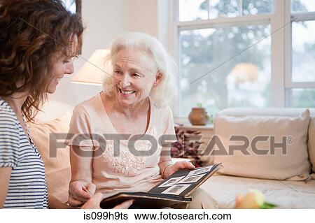 Senior woman and daughter looking through photo album View Large Photo Image Stock Photograph - Senior woman and daughter looking through photo album. Fotosearch