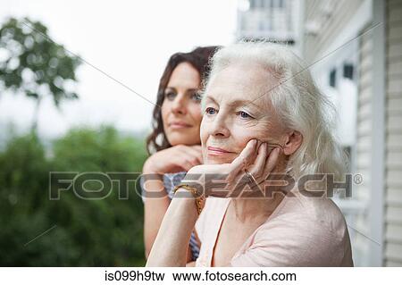 Stock Photo - Senior woman and daughter relaxing on porch. Fotosearch