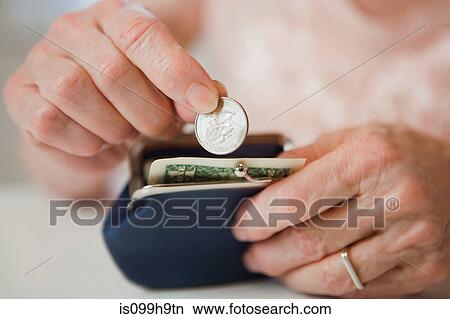 Picture - Senior woman saving money in purse. Fotosearch