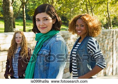 Three friends standing together in park, portrait View Large Photo Image Stock Image - Three friends standing together in park, portrait. Fotosearch