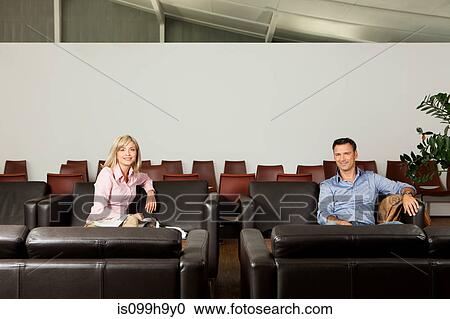 Travellers sitting in departue lounge of airport View Large Photo Image Stock Image - Travellers sitting in departue lounge of airport. Fotosearch